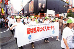 写真：横断幕を掲げて歌舞伎町をパレード（平成17年のキャンペーン）
