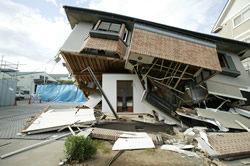 写真：倒壊した家屋の中に耐震シェルターが見える（イメージ）