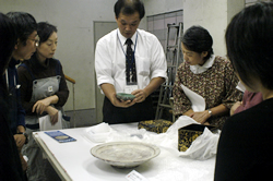 写真：学芸員から埋蔵物の解説を受ける参加者