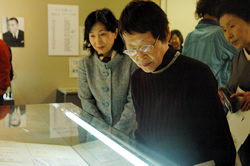 写真：展示を見学する松岡さんと中山区長