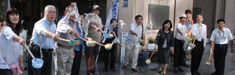 写真:本庁舎正面玄関前での打ち水