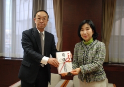 写真:つがる弘前農業協同組合の齊藤悟代表理事専務が中山弘子区長に目録を手渡す