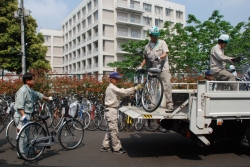 写真:女子高校生が乗りやすい大きさに整備した自転車をトラックに載せる