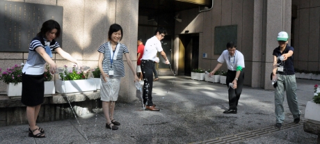 写真:区役所本庁舎前で打ち水を行う様子