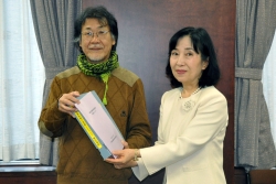 写真：久塚会長（写真左）が中山区長に見直し報告書を提出