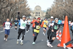 神宮外苑のイチョウ並木で手を振るランナー（昨年の様子）