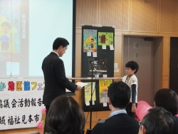 写真：防災児童画展で表彰する吉住区長