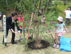 写真：記念植樹する吉住区長と子どもたち