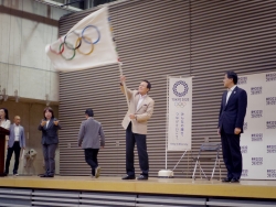 写真：オリンピックフラッグを振る釜本さん