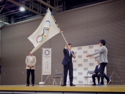 写真：オリンピックフラッグを振る吉住区長