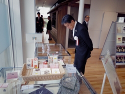 写真：ミュージアムショップでの販売品を見る吉住区長