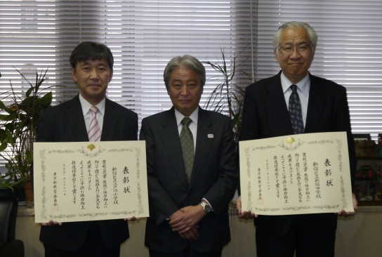 酒井教育長から表彰された江戸川小学校長と新宿中学校長の写真