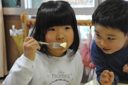 写真:リンゴをおいしそうにほおばる子ども2