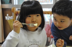 写真：リンゴをおいしそうにほおばる子ども2