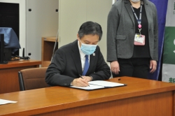 写真：吉住区長が署名する様子