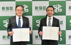 協定書を手に並ぶ吉住区長と株式会社ハミングバード鈴木社長