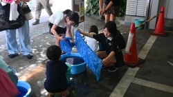 絞り染めを水洗いする子ども