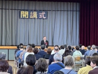 写真[1]：開校式でご挨拶する吉住区長