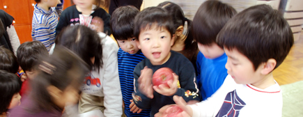写真:りんごを手に喜ぶ子どもたち