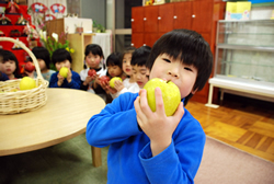 写真:りんごを手に喜ぶ子どもたち