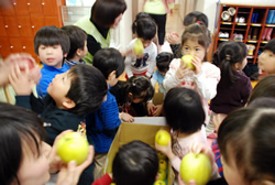 写真：りんごを手に喜ぶ子どもたち