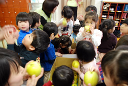 写真:りんごを手に喜ぶ子どもたち