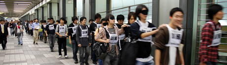 写真:アイマスクを着用して避難する学生