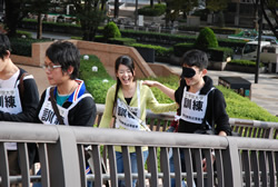 写真:アイマスクを着用して避難する学生