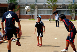 写真：ＦＣ東京の選手に指導を受ける男の子