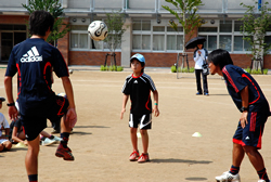 写真:FC東京の選手に指導を受ける男の子