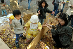 写真：落ち葉で遊ぶ子どもたち