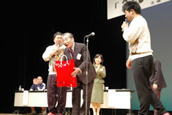 写真：受賞の大浦さんとダイノジの2人