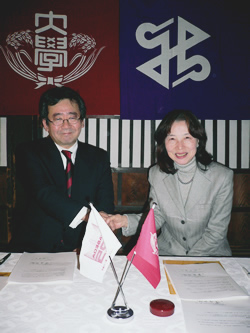 写真:調印後握手を交わす藁谷院長と金子教育長)
