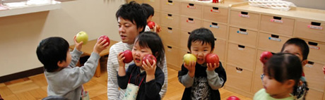 写真:りんごにほおずりする園児たち