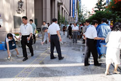 写真:水をまく区職員ら