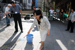 写真:水をまく中山区長