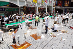 写真:炎天下のシネシティ広場で作業をする出場者たち