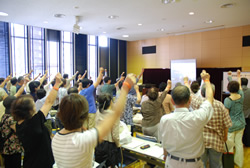 写真：オレンジリングを着けて手を挙げる参加者
