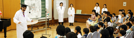 写真:白衣の研究者(中川賢一さん)の話を熱心に聴く参加者