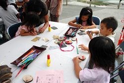 写真:真剣な表情で木のペンダントを作る子どもたち
