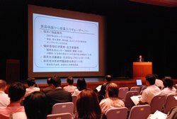 写真：スクリーンを使って講演する松本教授