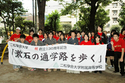 写真：横断幕「漱石の通学路を歩く」と記念撮影