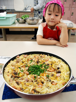 写真:完成した料理を前に審査を待つ女の子