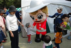 写真:新宿シンちゃんと握手する子ども