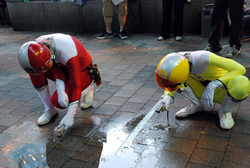 写真:打ち水後の温度を測る新宿エコレンジャー