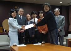 新宿区協働事業提案制度審査会委員から区長へ報告書を提出する様子<左から中山区長、伊藤清和委員、内山委員、丹委員、伊藤圭子委員、久塚審査会長、宇都木審査副会長、>
