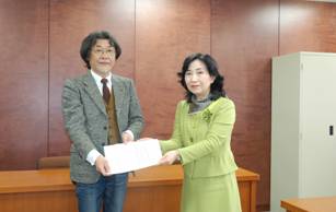 協働支援会議委員から区長へ報告書を提出する様子<左から久塚座長、新宿区長>