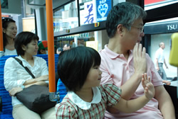 写真:バスの中から手を振る女の子