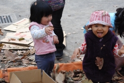 写真:落ち葉のプールで遊ぶ子どもたち