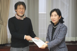 写真：報告書を提出する久塚会長